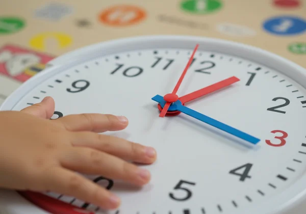 Kids learning hour and minute hands on a clock.