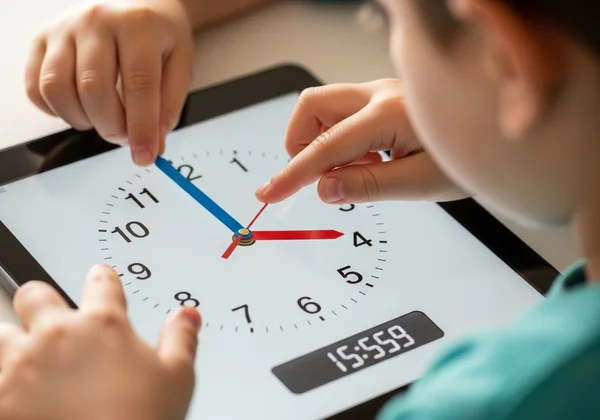 Child dragging hands on an interactive analog clock interface